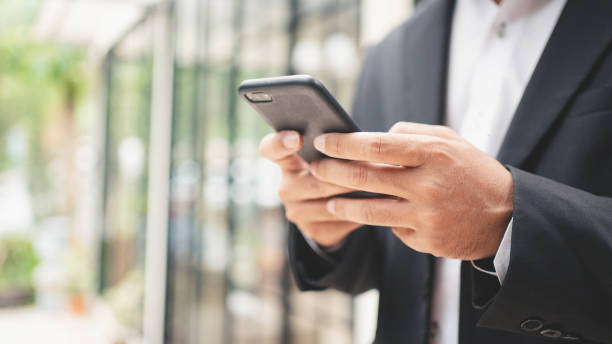 istock Close up businessman typing on smart phone and smilling 1399315649