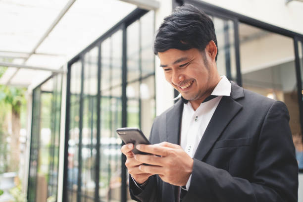 istock Close up businessman typing on smart phone and smilling 1399315708