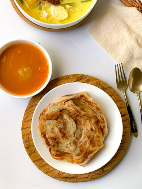 Roti Canai Roti Paratha or Roti Canai with curry sauce, a popular Malaysian breakfast roti canai stock pictures, royalty-free photos & images