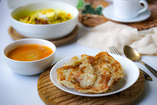 Roti Canai Roti Paratha or Roti Canai with curry sauce, a popular Malaysian breakfast roti canai stock pictures, royalty-free photos & images