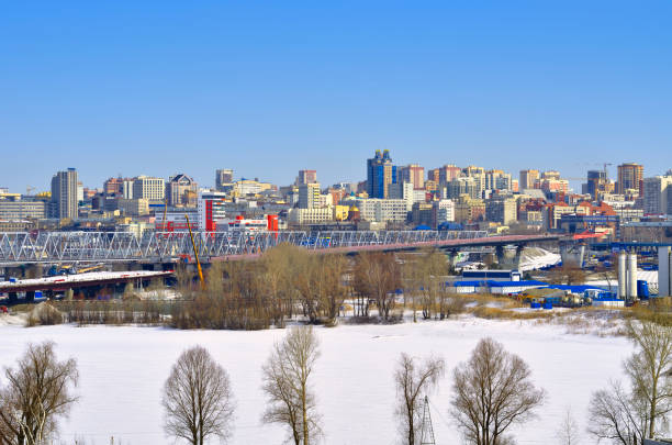 Panorama of the big city Novosibirsk, Siberia, Russia, 03.27.2022. Panorama of the big city. Railway bridge in the Central district on the banks of the Ob river in spring bare tree snow tree winter stock pictures, royalty-free photos & images