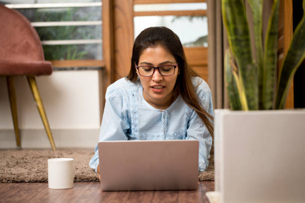 istock Young woman using laptop at home 1399321519
