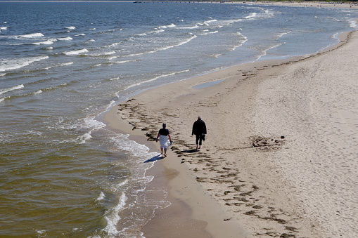 Heringsdorf, Germany, May 9, 2022 - An unidentified elderly couple walking on beautiful sandy beach
