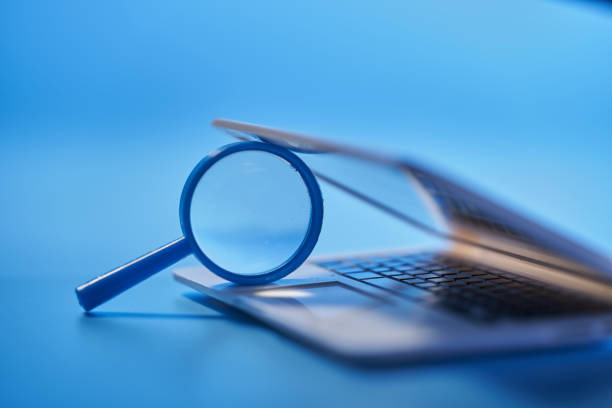 istock close up of magnifying glass with small laptop 1399326821