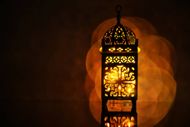 istock Ornamental Arabic lantern with burning candle glowing at night. 1399326952