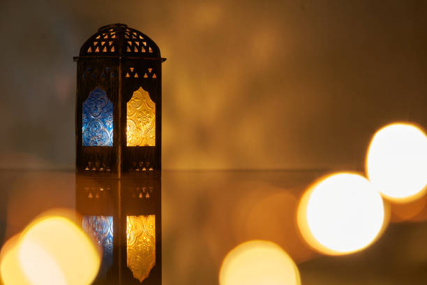istock Ornamental Arabic lantern with burning candle glowing at night. 1399327047