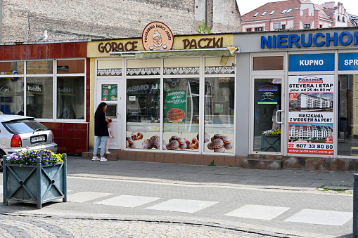 Świnoujście, Poland, May 11, 2022 - Gorące Paczki Donut Bakery / Donut Shop in Świnoujście, some unidentified people in the background