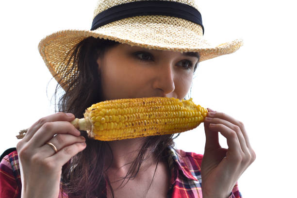 istock Young woman in hat eating grilled corn against white background 1399327639