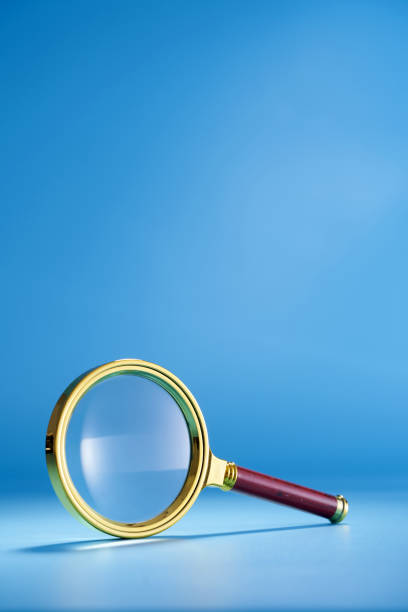 istock gold colored frame of magnifying glass wth red handle against blue background 1399327660
