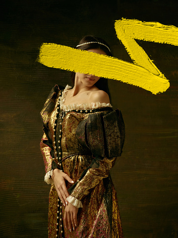 Obra creativa. Retrato de niña en imagen de princesa medieval o condesa con trazo amarillo de pintura de acuarela sobre fondo oscuro. Arte contemporáneo, concepto de comparación de épocas photo