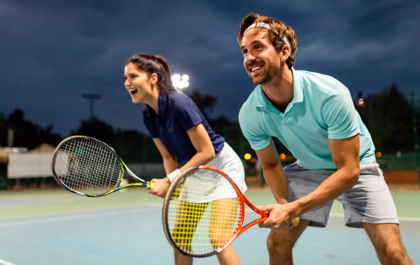 beautiful young people are playing tennis as a team on tennis court outdoors. people sport concept - tennis couple women men imagens e fotografias de stock