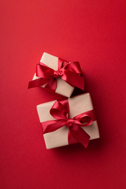 istock Christmas gift boxes tied red ribbons on red background. 1399328832