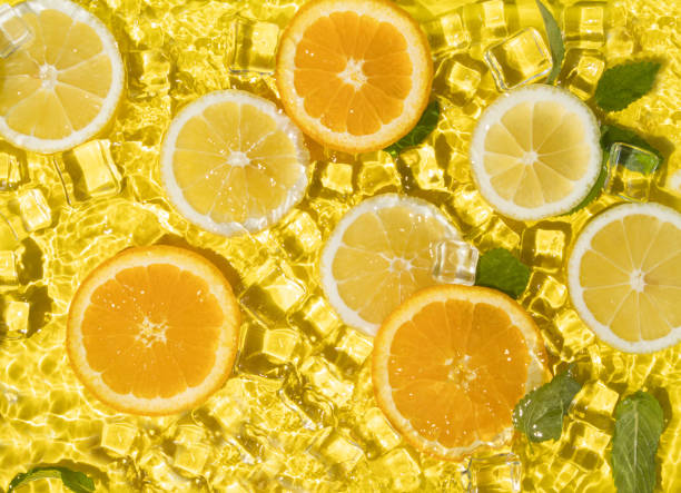 Tropical fruit pattern of orange, lime and lemon slices with ice cubes. Summer composition of fruits and vitamins. Summer vibes.
