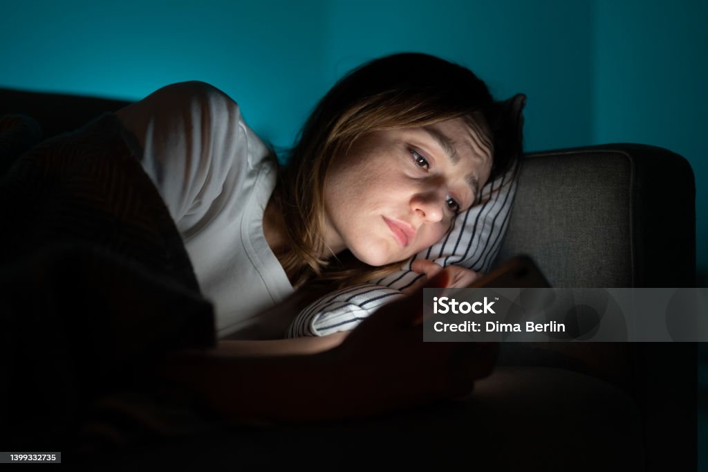 Woman Using Mobile Phone While Lying In Bed At Night Suffering From ...