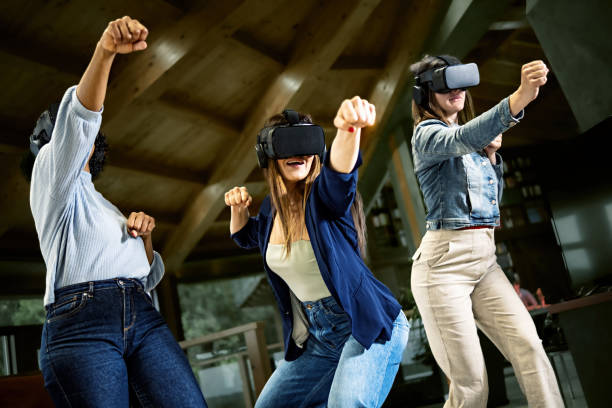 istock Group of young women using virtual reality headset - Girlfriends playing ninja fight video games in meta verse space with futuristic goggles having fun together 1399336316