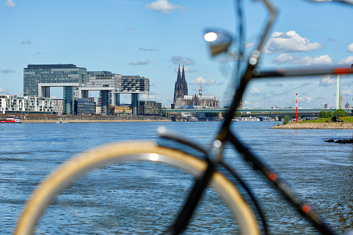 By bike along the Rhine near Cologne. Crane houses (Kranhäuser) and Cologne Cathedral in the background.