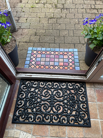 Stock photo showing the interior and exterior non slip, rubber doormats in front of a glazed porch.