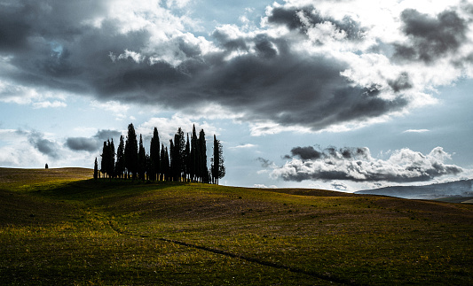 Beautiful view at Val d'Orcia against moody clouds. Panoramic shot. Italy, Tuscany