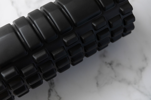 Black foam roller to help relieve muscle tightness.