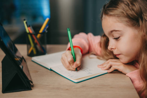 istock Caucasian girl doing homework and study online with tablet at the desk. Child studying from home. Homeschooling during quarantine and coronavirus outbreak. e-Learning. Online class. 1399342746