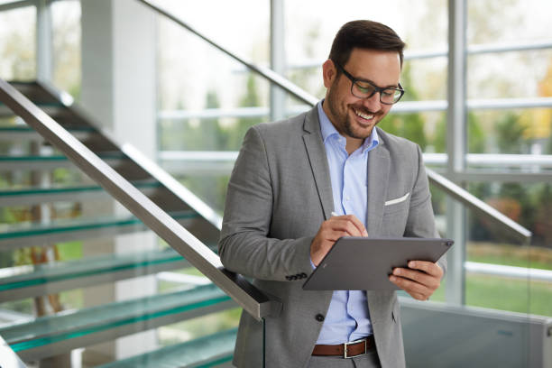 istock Businessman using digital tablet in an office building lobby 1399344626