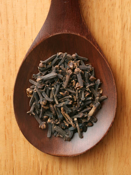 Cloves Top view of wooden spoon with cloves on it clove spice stock pictures, royalty-free photos & images