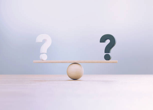 White And Black Question Marks Sitting Over Wooden Seesaw Scale Before Defocused Background White and black question marks sitting over wooden seesaw scale before defocused background. comparison stock pictures, royalty-free photos & images