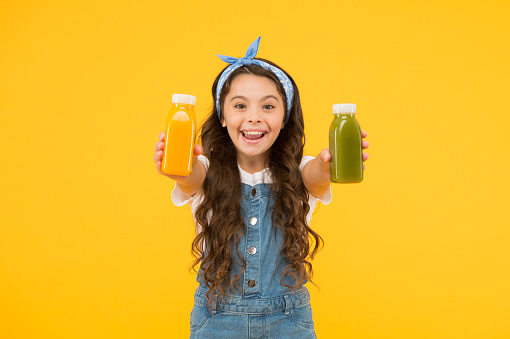 Berries in my bottle. Fruit energy. Smiling kid hold smoothie bottles. Healthy food. Vitamin nutrition. Fresh smoothie. Girl drinking orange fresh smoothie. Vegetarian concept. Vitamin juice.