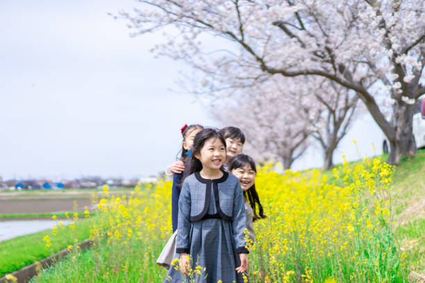 istock Elementary school girls playing together in a flower garden 1399346898