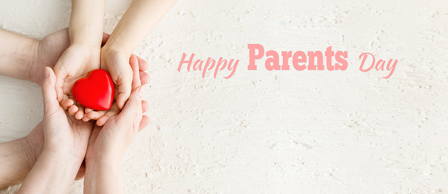 Concept Happy Parents Day or International Day of Families. Father, child and mother holding Heart in the hands on white background. Greeting card.