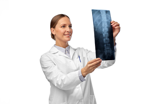 medicine, radiology and healthcare concept - happy smiling female doctor in white coat with x-ray scan image of spine