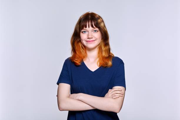 istock Portrait of young red-haired female looking at camera on light studio background 1399348487