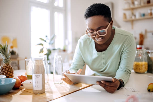 istock Young woman taking order for smoothie shop on digital tablet 1399349467