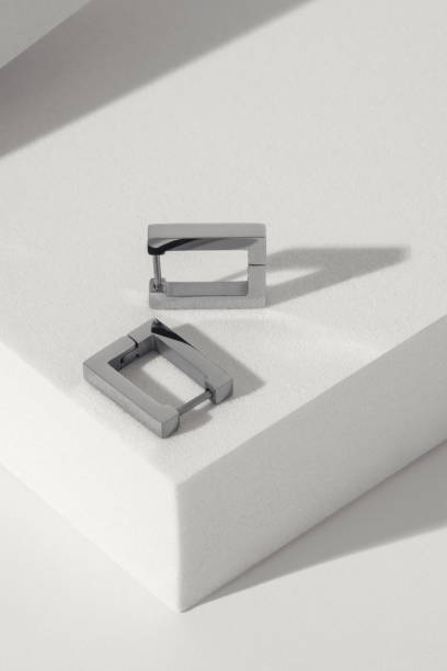 istock Vertical shot of Silver modern earrings pair on white background with copy space 1399351175