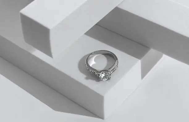 Photo of Diamonds ring on geometric white background with copy space
