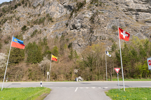 Balzers, Liechtenstein, April 11, 2022 Waving national flags at the border between Liechtenstein and Switzerland