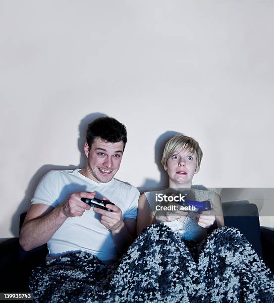 Pareja Jugando Juegos De Video Foto de stock y más banco de imágenes de Sofá - Sofá, Videojuego, Hombres