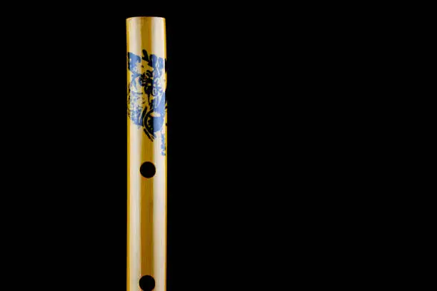 Closeup view of chinese bamboo flute isolated against a black background
