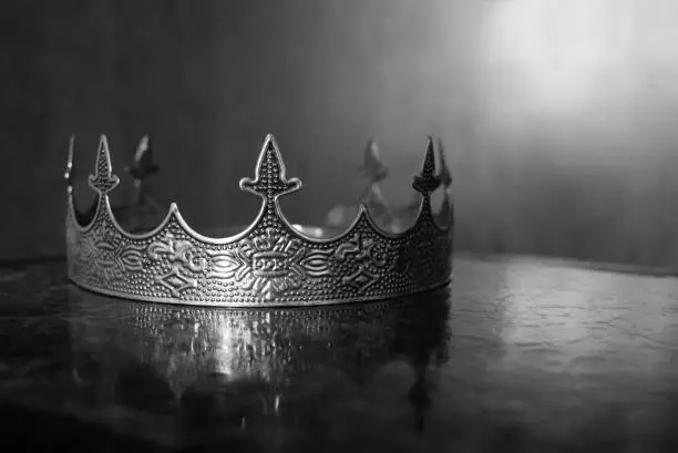 Photo of Vintage royal crown for man, jewellery. Concept of power and wealth, king. Black and white