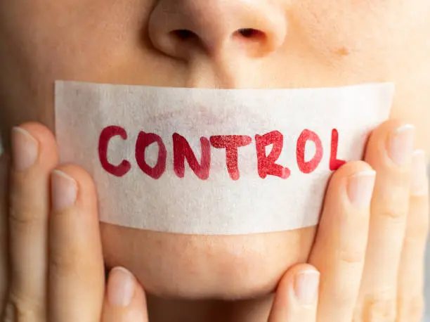 Photo of Control your tongue. Female holding plastered tape and covering her lips