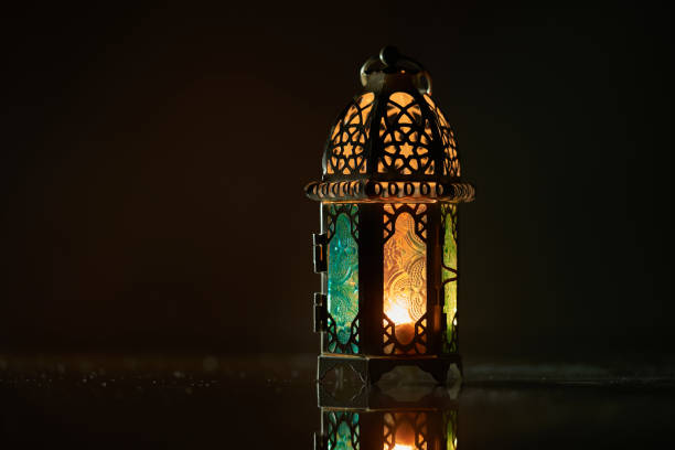 istock Ornamental Arabic lantern with burning candle glowing at night. 1399360023