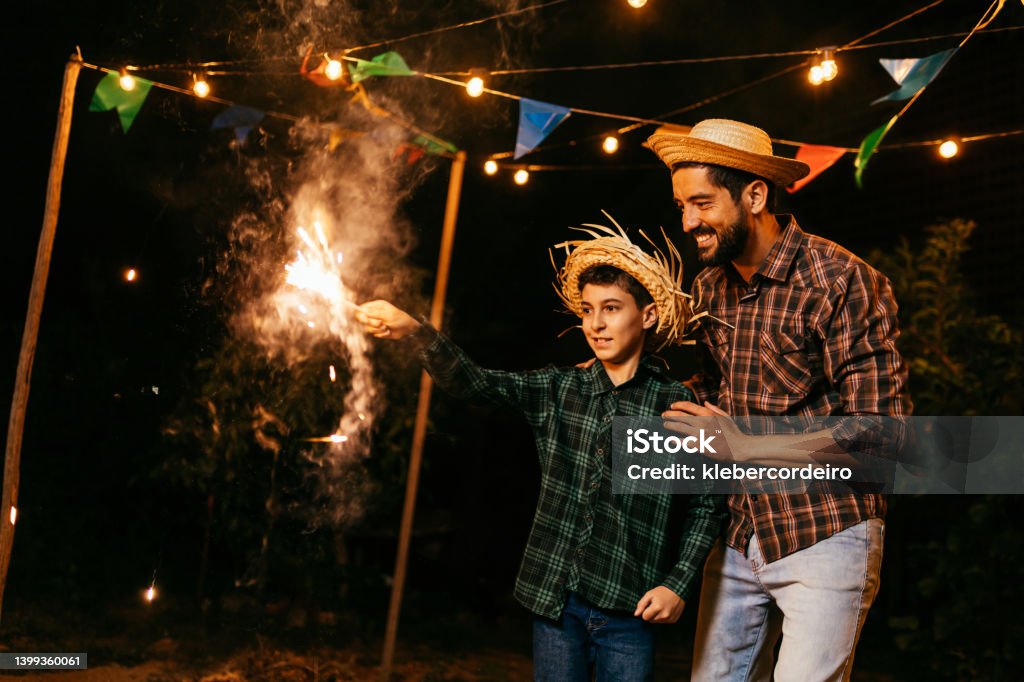 Child playing with fireworks during the traditional Festa Junina in Brazil. Festa Junina Stock Photo
