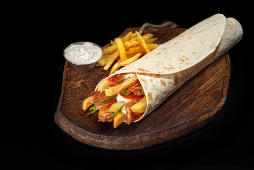 pork shawarma, doner kebab burrito stuffing for, french fries and pork with pita bread, dish on a tray healthy snack, copy space, food background, vegan food, close-up