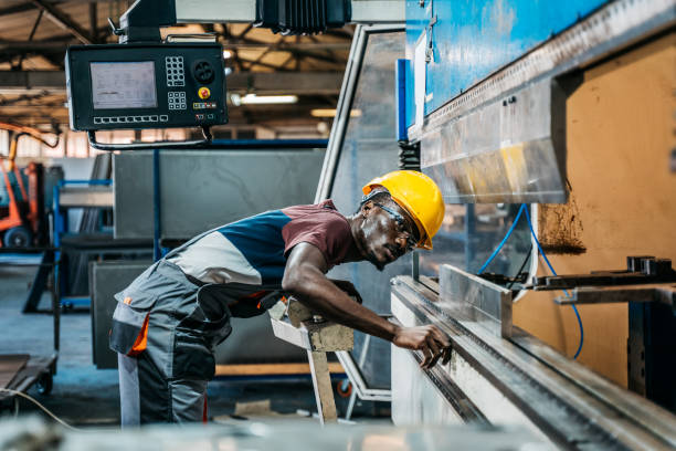 istock Afro american worker using machine in faktory 1399360831