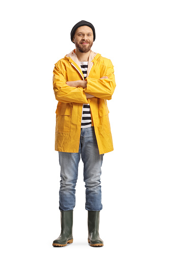 Retrato de cuerpo entero de un pescador con un impermeable amarillo y botas de goma photo