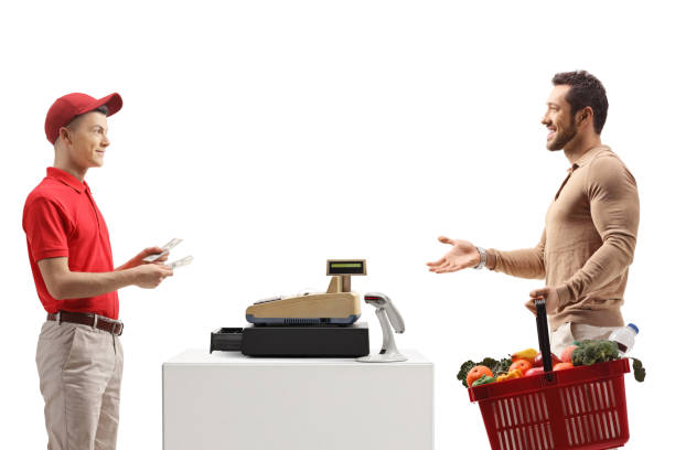 male customer with a shopping basket paying at a cash register - retail occupation cash register retail selling imagens e fotografias de stock