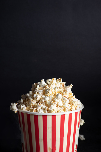 Sweet popcorn box with popcorn on black background