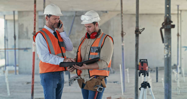 istock A building contractor talking on a phone while filling in paperwork from a colleague on a construction site. Two men working as a team on an architecture project. Engineers discussing plans 1399364877
