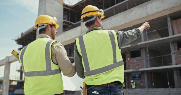 istock Builders reading a blueprint and talking at a construction site. Two men working as a team on an architecture project. Engineers and colleagues discussing plans 1399364899