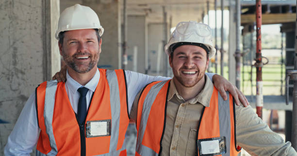 istock Portrait of two building contractors working on a construction site. Two happy men working on an architecture project, looking at the camera 1399364916